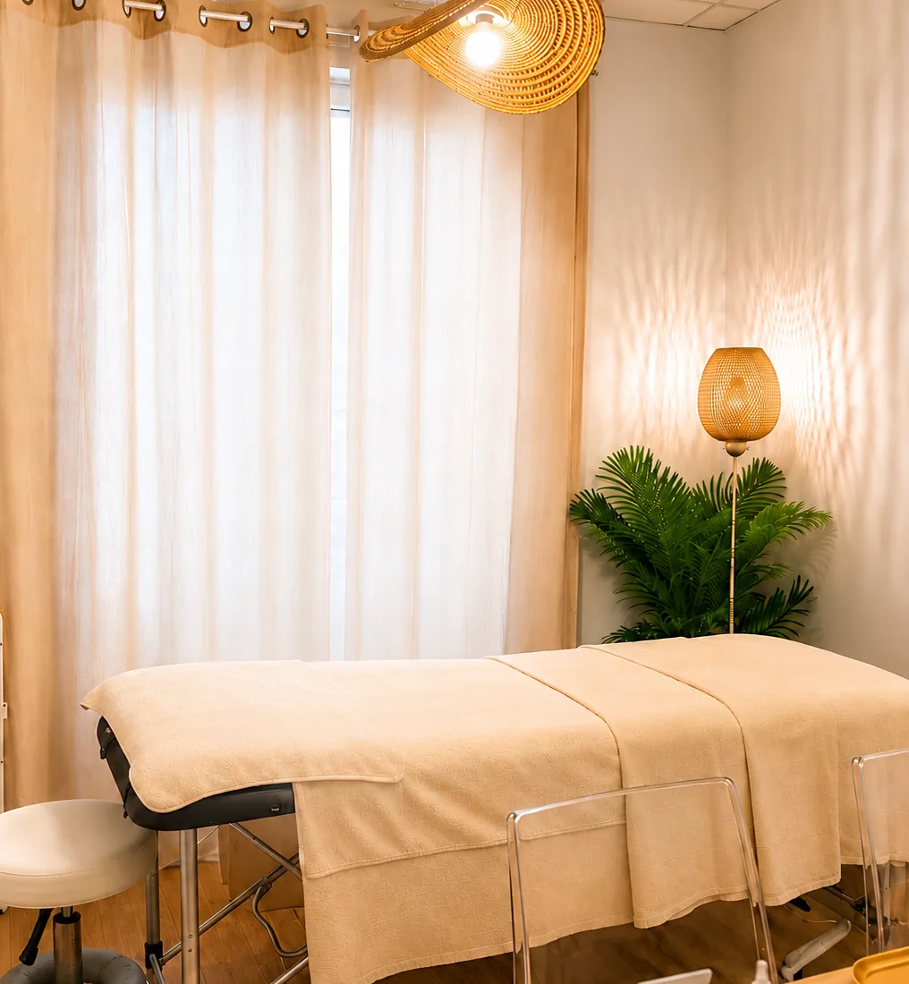 La salle de soin YALUNA à Marseille 1er : table de massage, voilages lin, lampe en rotin et palmier